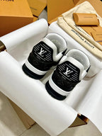 Low-top trainer sneakers close-up, black and white with LV monogram on tongue