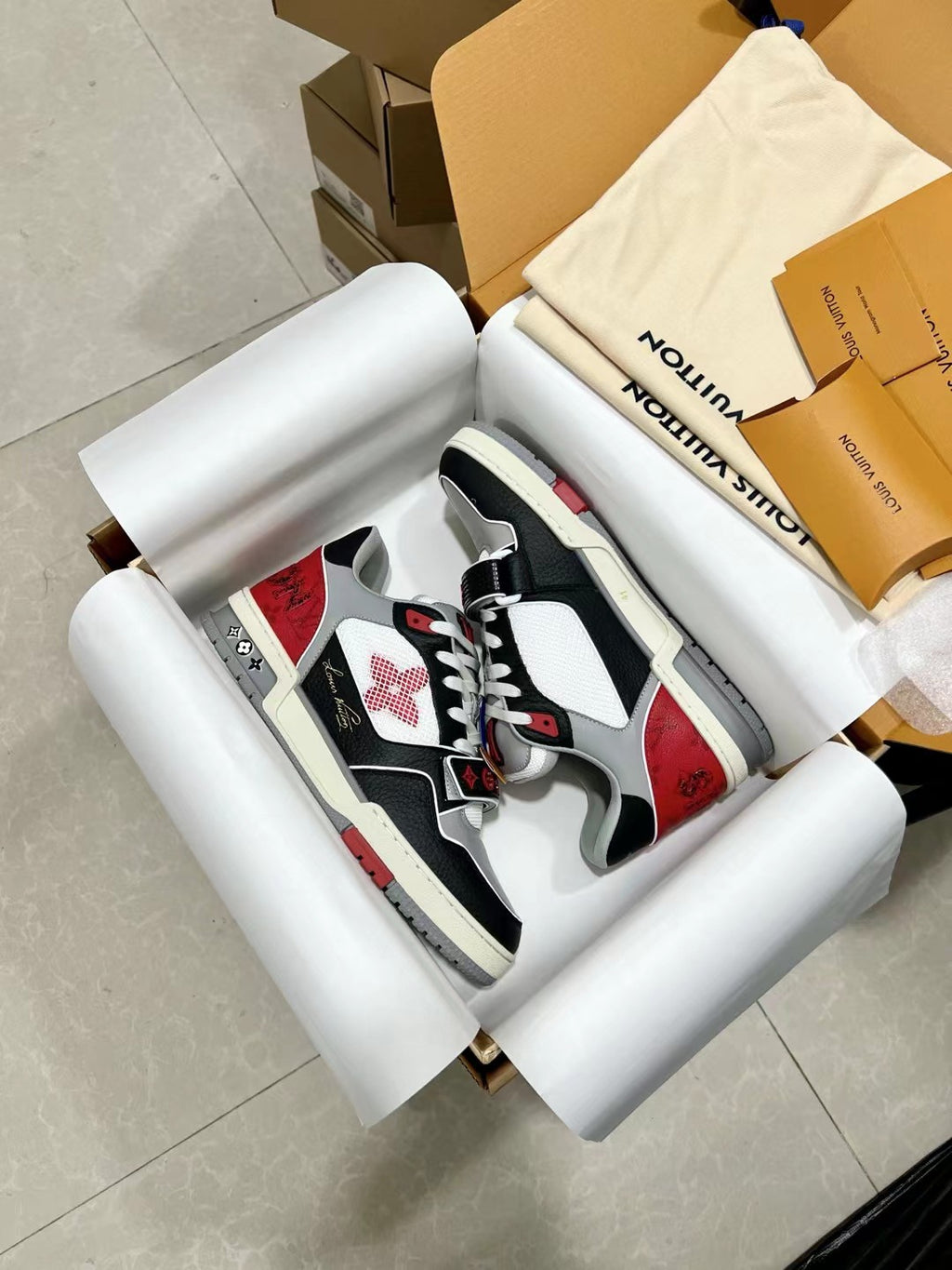 Black and white lace-up sneakers with red panels, shown from side angle