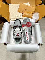 Front and outsole view of black, white, and red lace-up sneakers with red outsole text