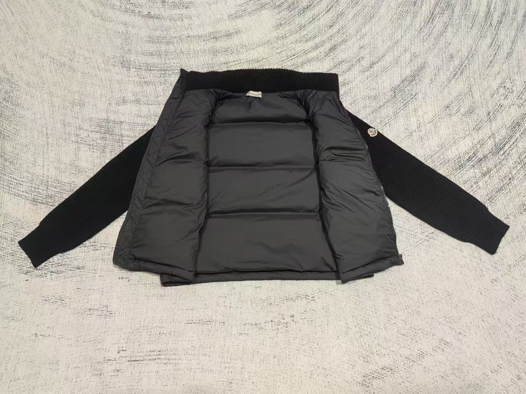 Long puffer jacket laid flat, stand collar, quilted interior panels and front zipper