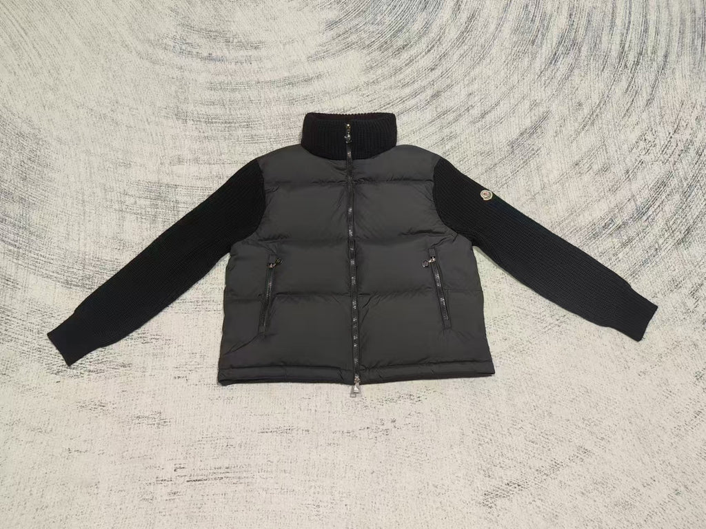 Long puffer jacket front view with knit sleeves, stand collar, visible front zipper