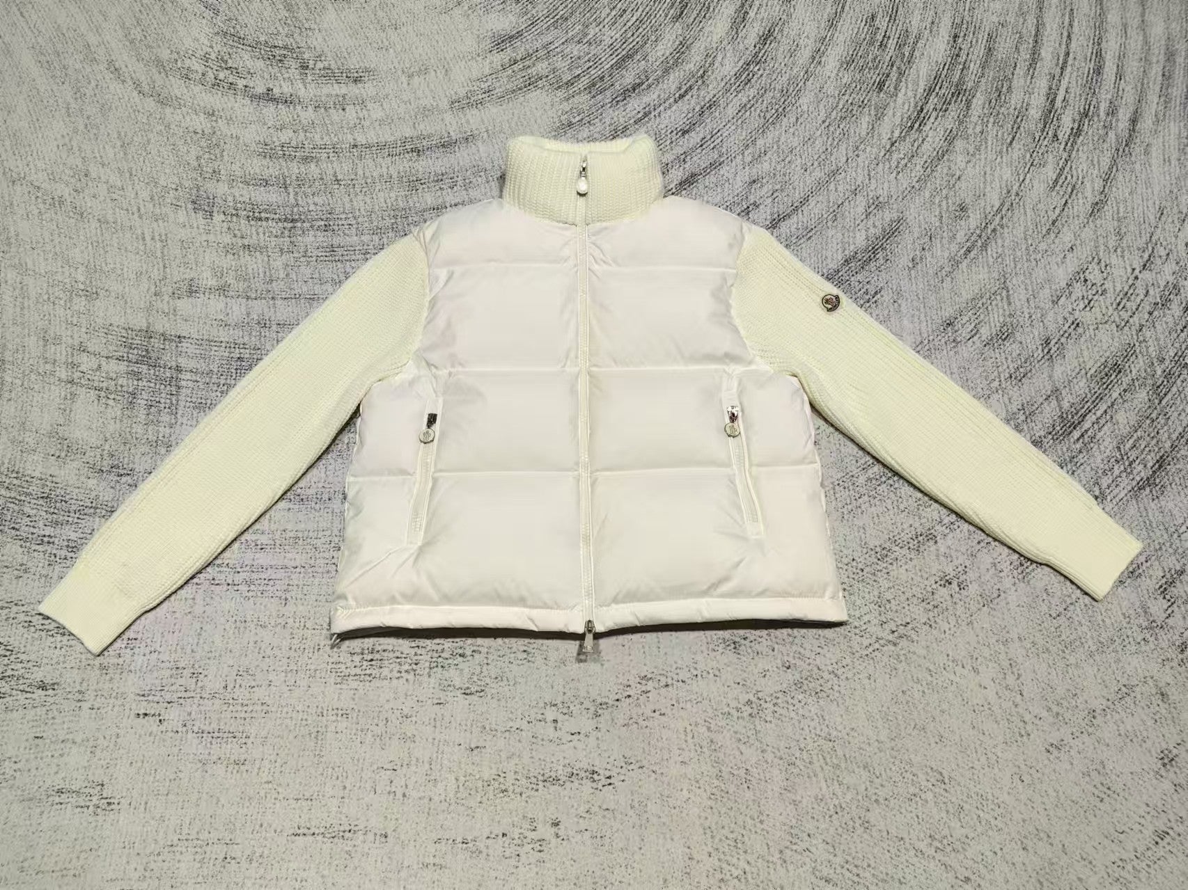 Cream puffer jacket with high neck, zip front, snap pockets, knit cuffs