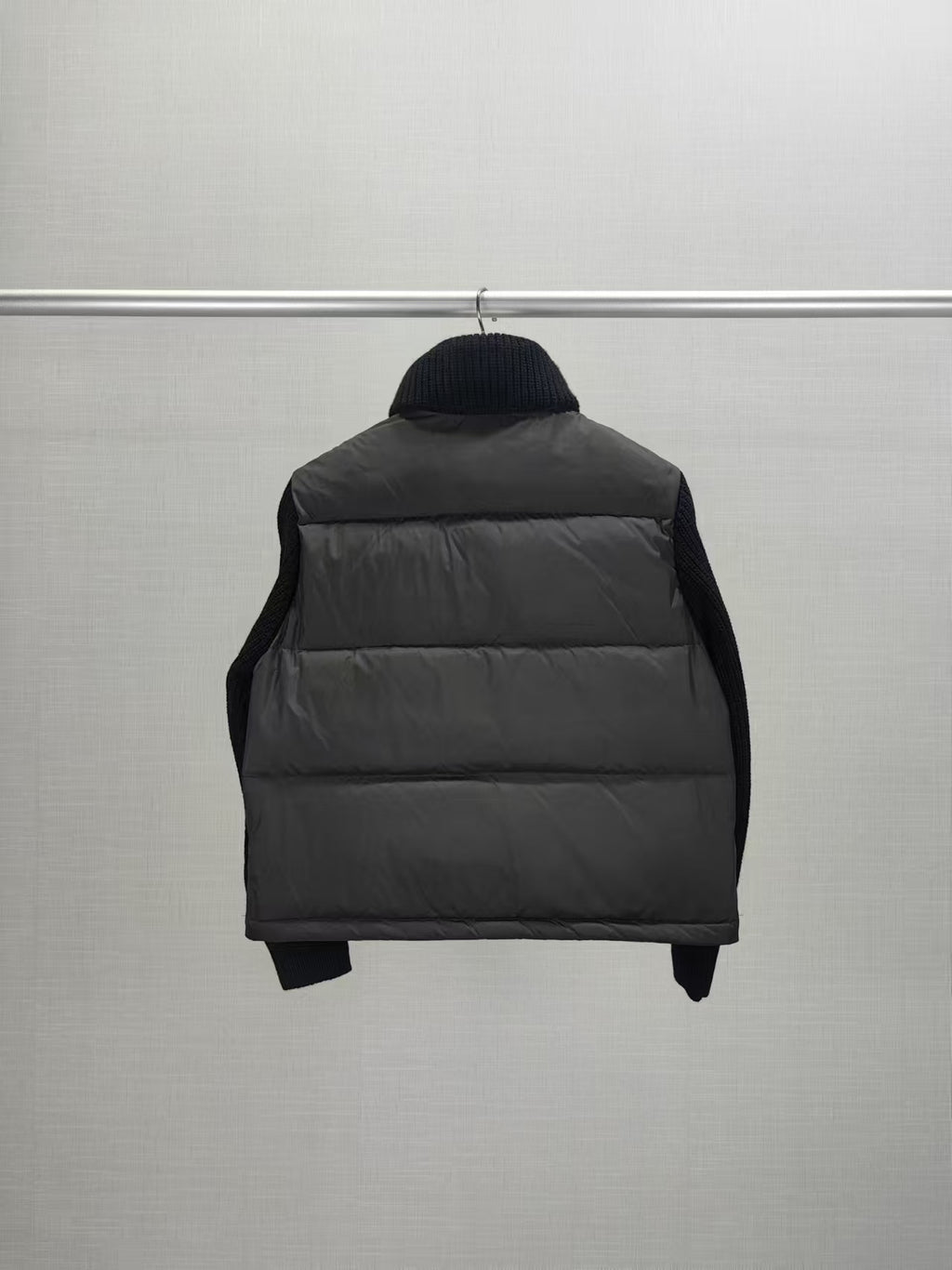 Long puffer jacket back view with dark hood collar and quilted puffer panels