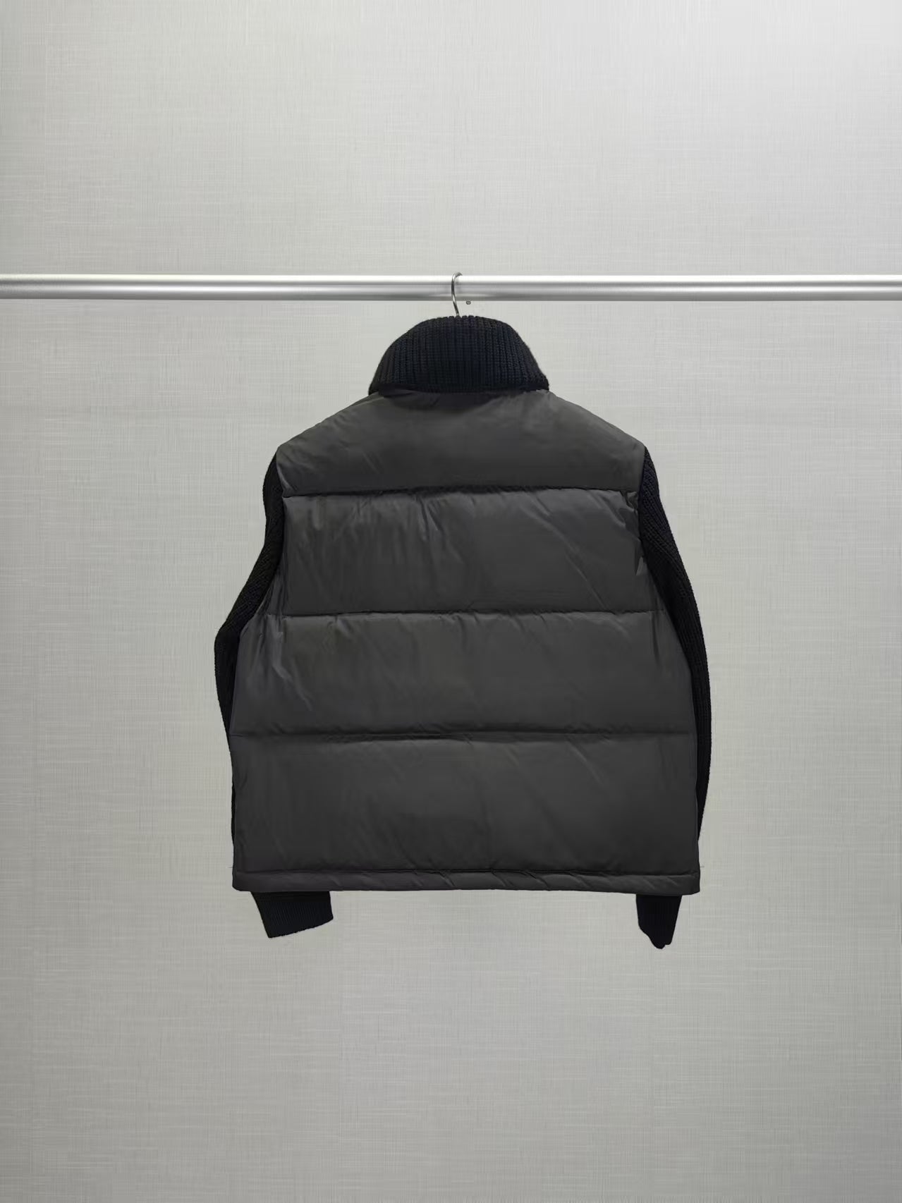 Long puffer jacket back view with dark hood collar and quilted puffer panels