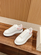 White lace-up sneakers with pink suede heel and tonal stitching