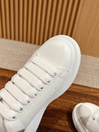 Close-up of a white leather sneaker upper with laces and rubber sole edge