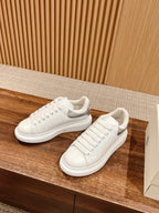 White leather low-top sneakers with side stitch detail and lace-up design