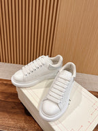 White leather lace-up sneakers with textured sole and clean seam details