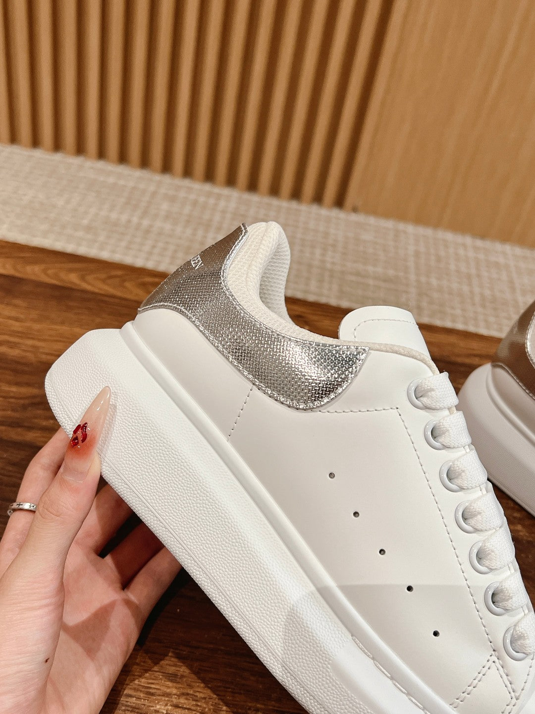 White low-top sneakers with silver glitter heel panel and lace-up front