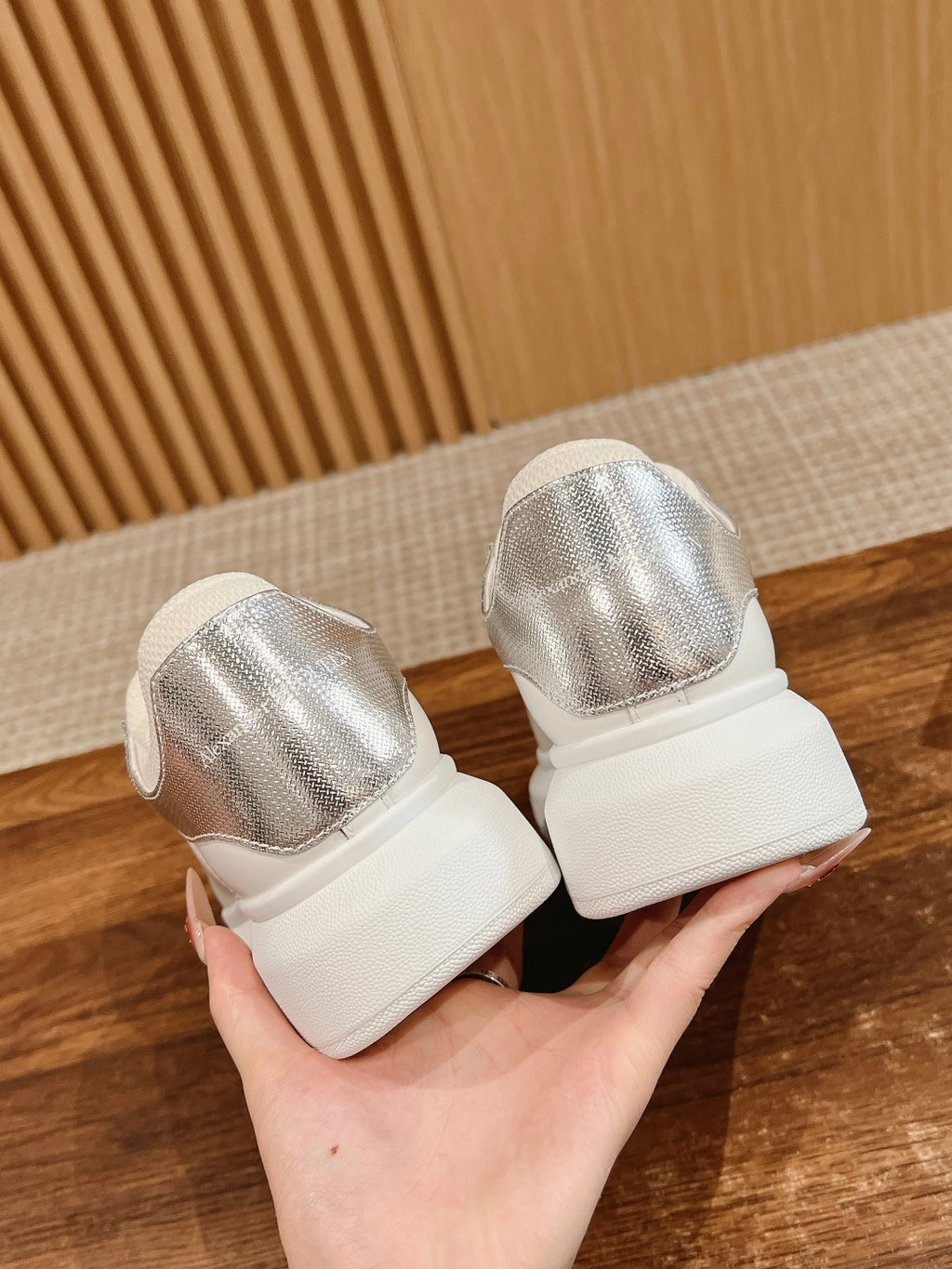 Pair of white sneakers with metallic silver back panels