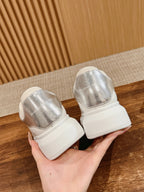 Pair of white sneakers with metallic silver back panels