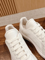 White leather lace-up sneakers close-up, side seams and padded collar visible