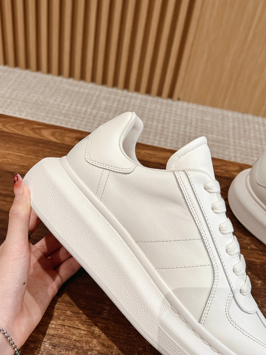 White low-top sneakers with lace-up closure and smooth leather side panels