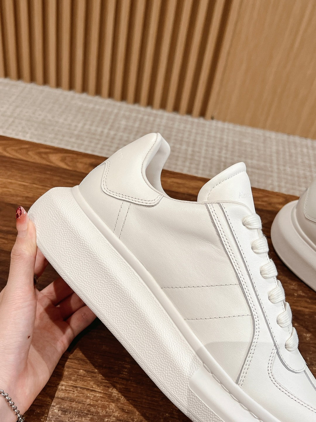White low-top sneakers with lace-up closure and smooth leather side panels