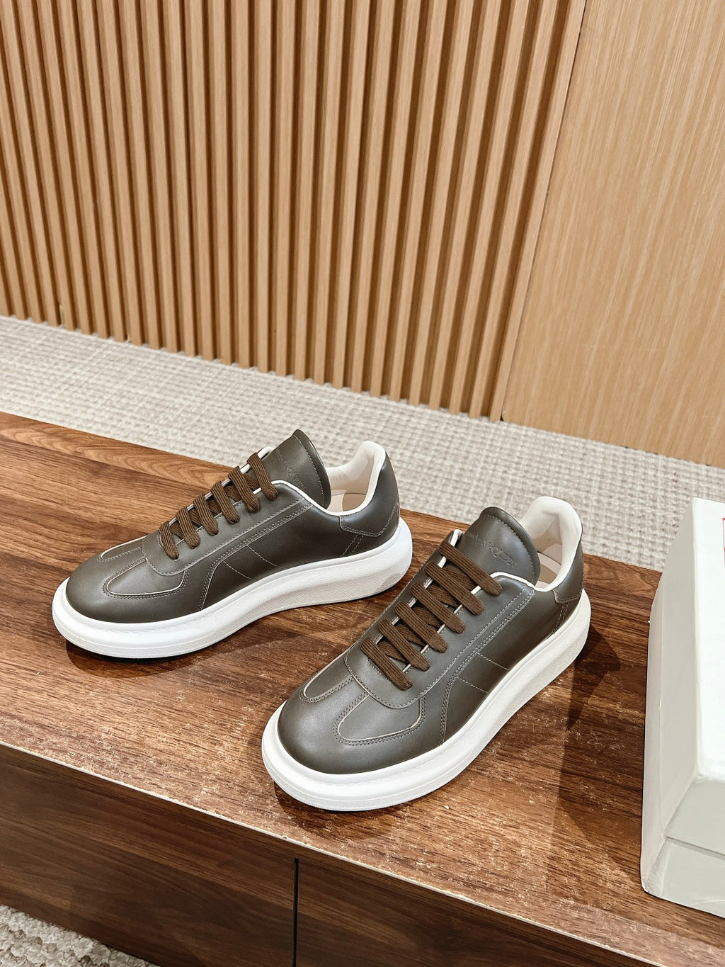 Dark gray leather low-top sneakers on display with white rubber soles