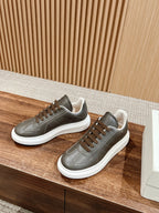 Dark gray leather low-top sneakers on display with white rubber soles