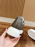 Back view of dark gray leather low-top sneaker with white sole and heel tab