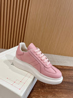 Pink low-top sneakers with lace-up front and white sole, side view
