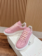 Pink Alexander McQueen sneakers with thick white sole and lace-up laces