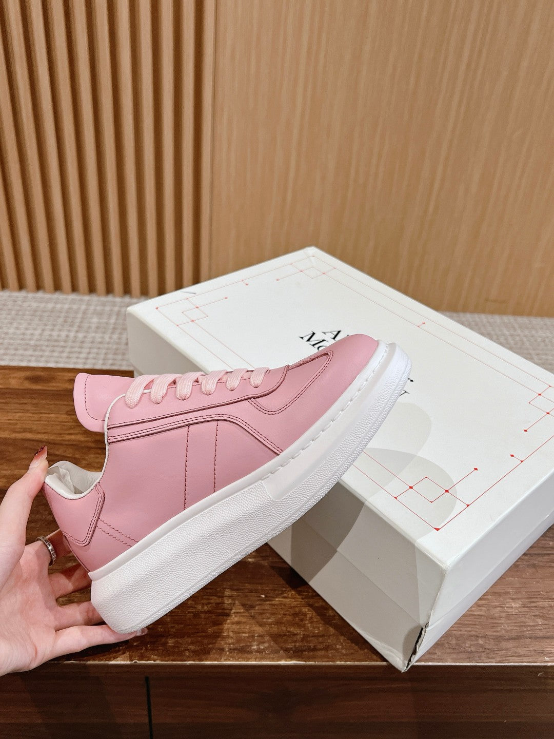 Pink Alexander McQueen sneakers with lace-up front and white rubber sole