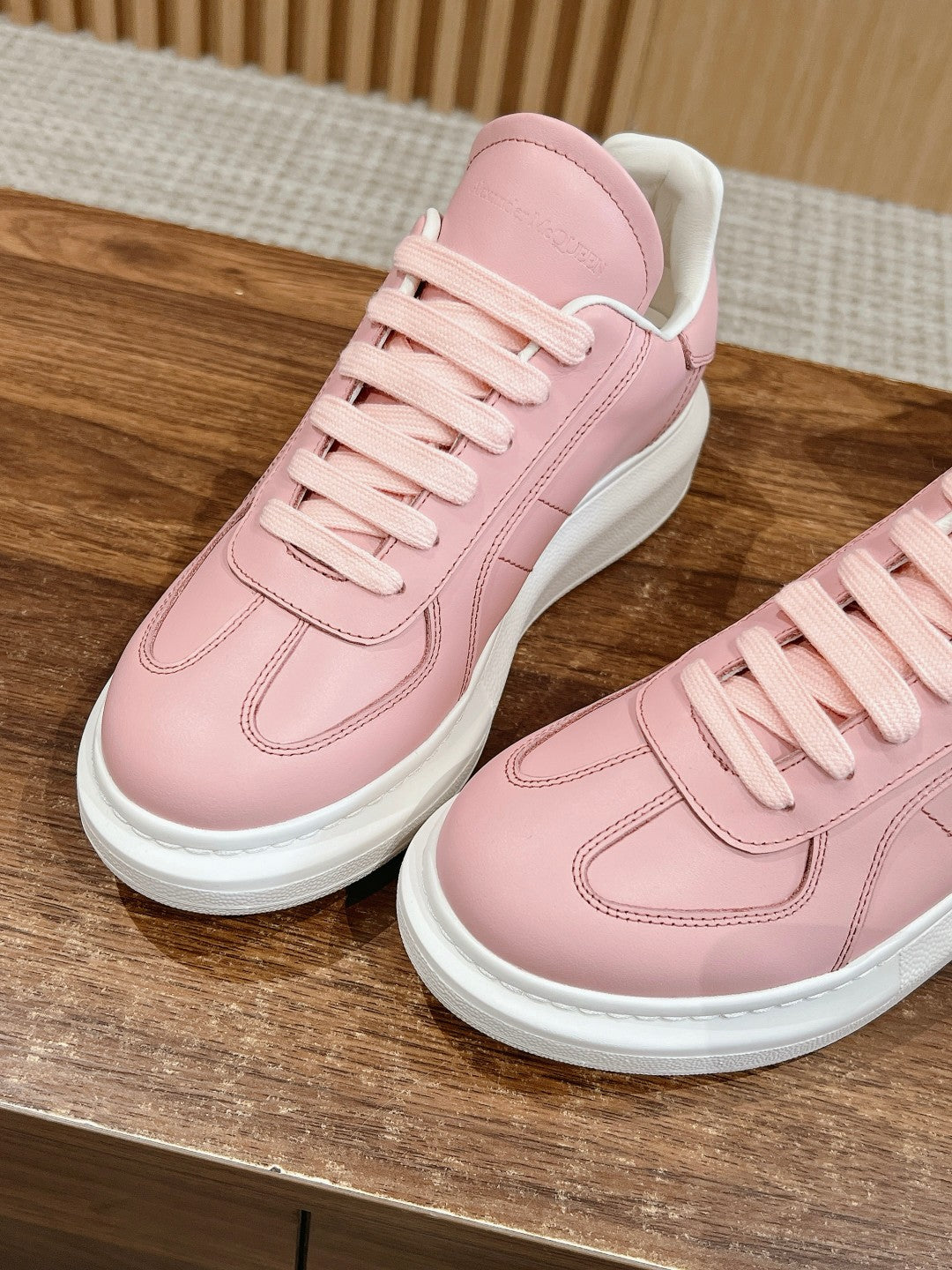 Pink leather sneakers, lace-up with stitched seams and white outsole