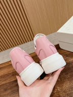 Pink Alexander McQueen sneakers with white soles, back view in hand
