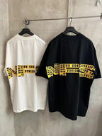 White and black short-sleeve T-shirts with yellow “Need for speed” stripe graphic.