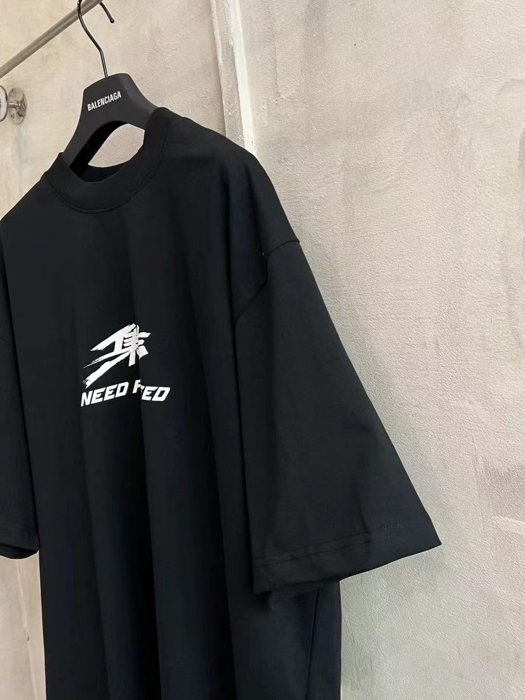 Black short-sleeve T-shirt with white “NEED FOR SPEED” graphic on front.