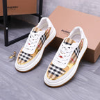 White Burberry sneakers with check panel uppers, gold accents, and orange sole
