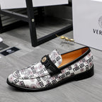 Versace slip-on loafers with white geometric print, black strap, gold buckle medallion.