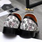 Versace loafer pair with black heel trim, white patterned uppers, round toe.