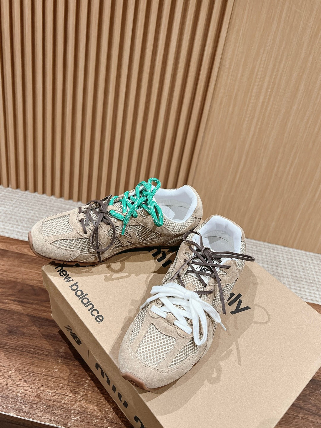 Prada unisex sneakers pair, beige uppers with teal laces and white lace front view