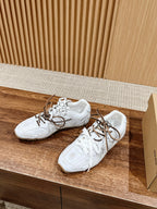 White low-top sneakers with brown laces, side view on wooden shelf