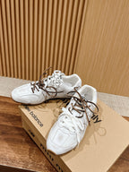 White low-top sneakers with brown laces resting on shoebox