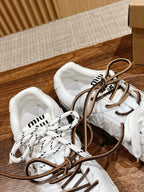 Pair of white low-top sneakers with brown laces, top view