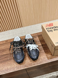Pair of black unisex sneakers with white laces and padded collars