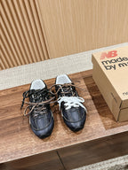 Pair of black unisex sneakers with white laces and padded collars