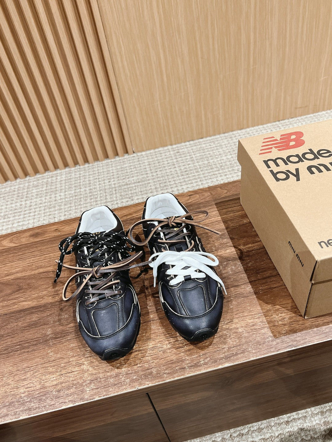 Pair of black unisex sneakers with white laces and padded collars