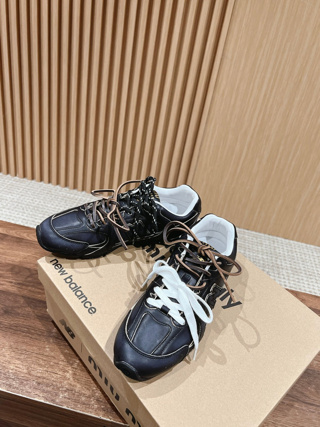 Black unisex sneakers with white and black laces, lace-up front