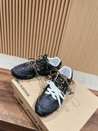 Black unisex sneakers with white and black laces, lace-up front