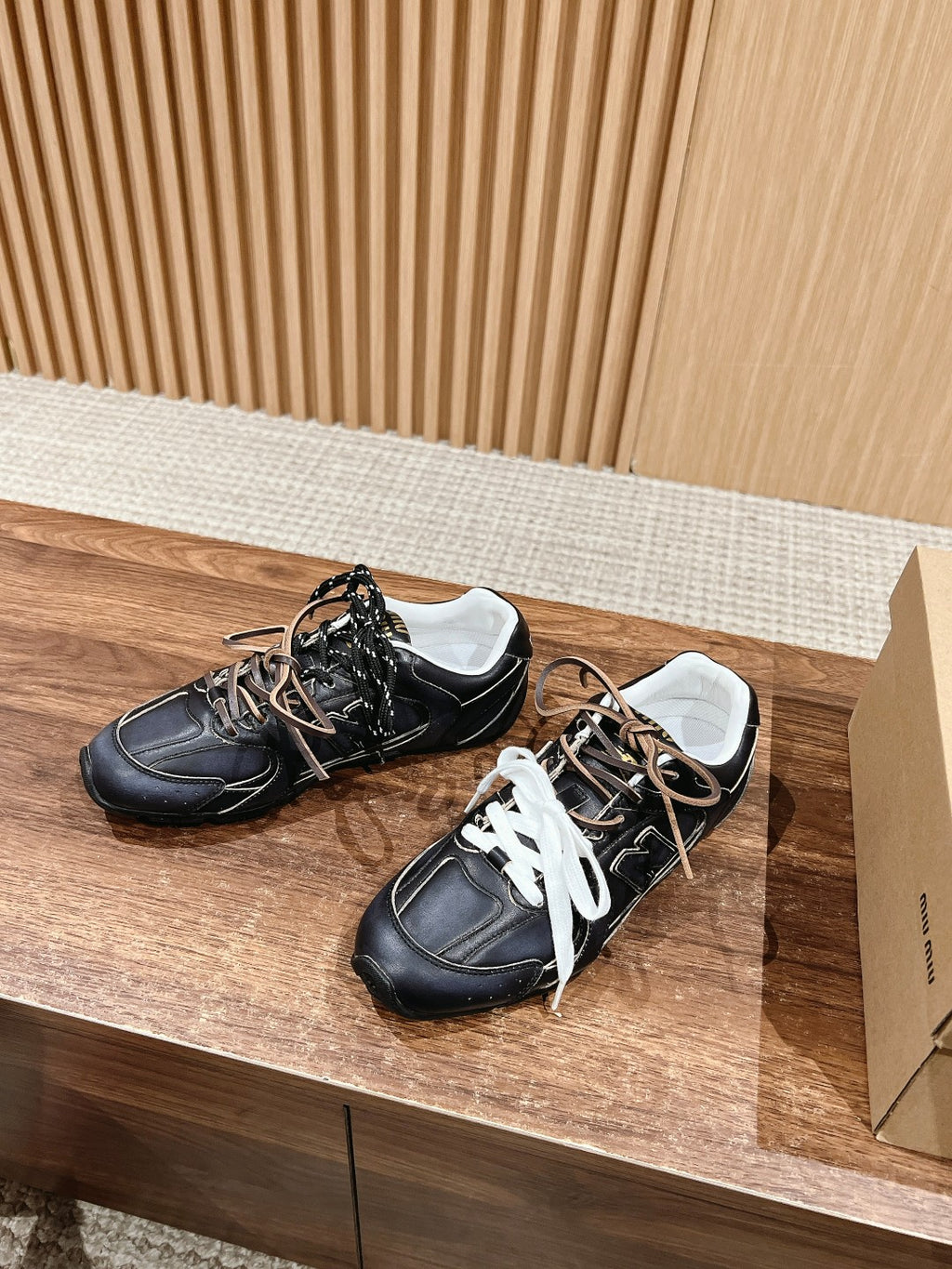 Pair of black unisex sneakers with white laces and contrast stitching