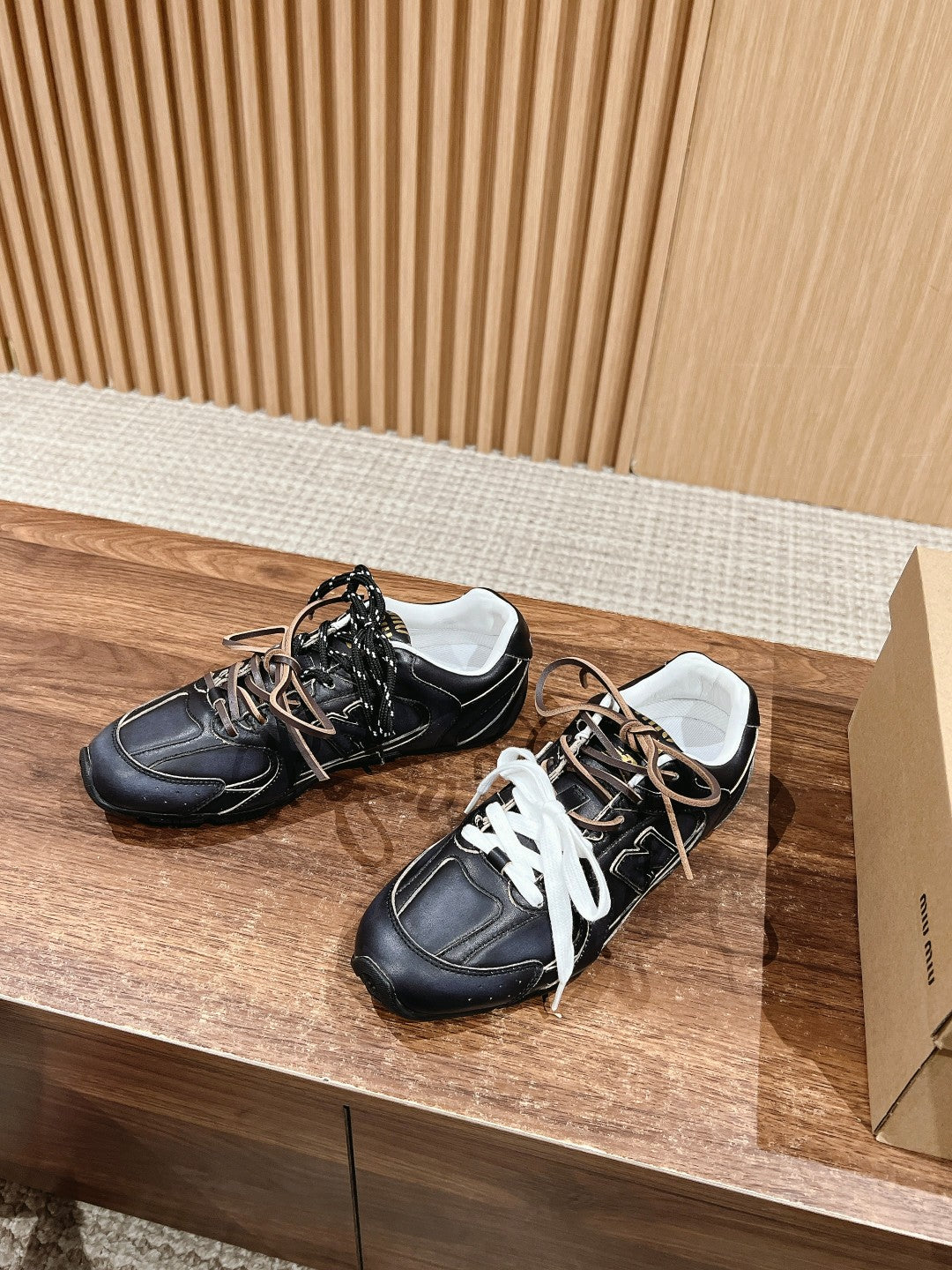 Pair of black unisex sneakers with white laces and contrast stitching