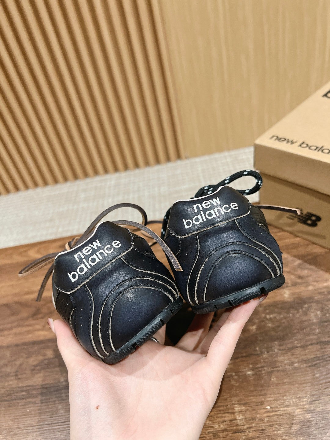 Black unisex sneakers with “new balance” text on heel tabs