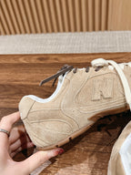 Unisex suede sneakers with white laces and N logo on side, hands holding