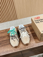 Unisex suede sneakers with green laces, white sole, and logo detail