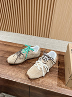 Unisex suede sneakers with green laces and white laces, box nearby