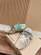 Unisex suede sneakers with green and black laces on brand box