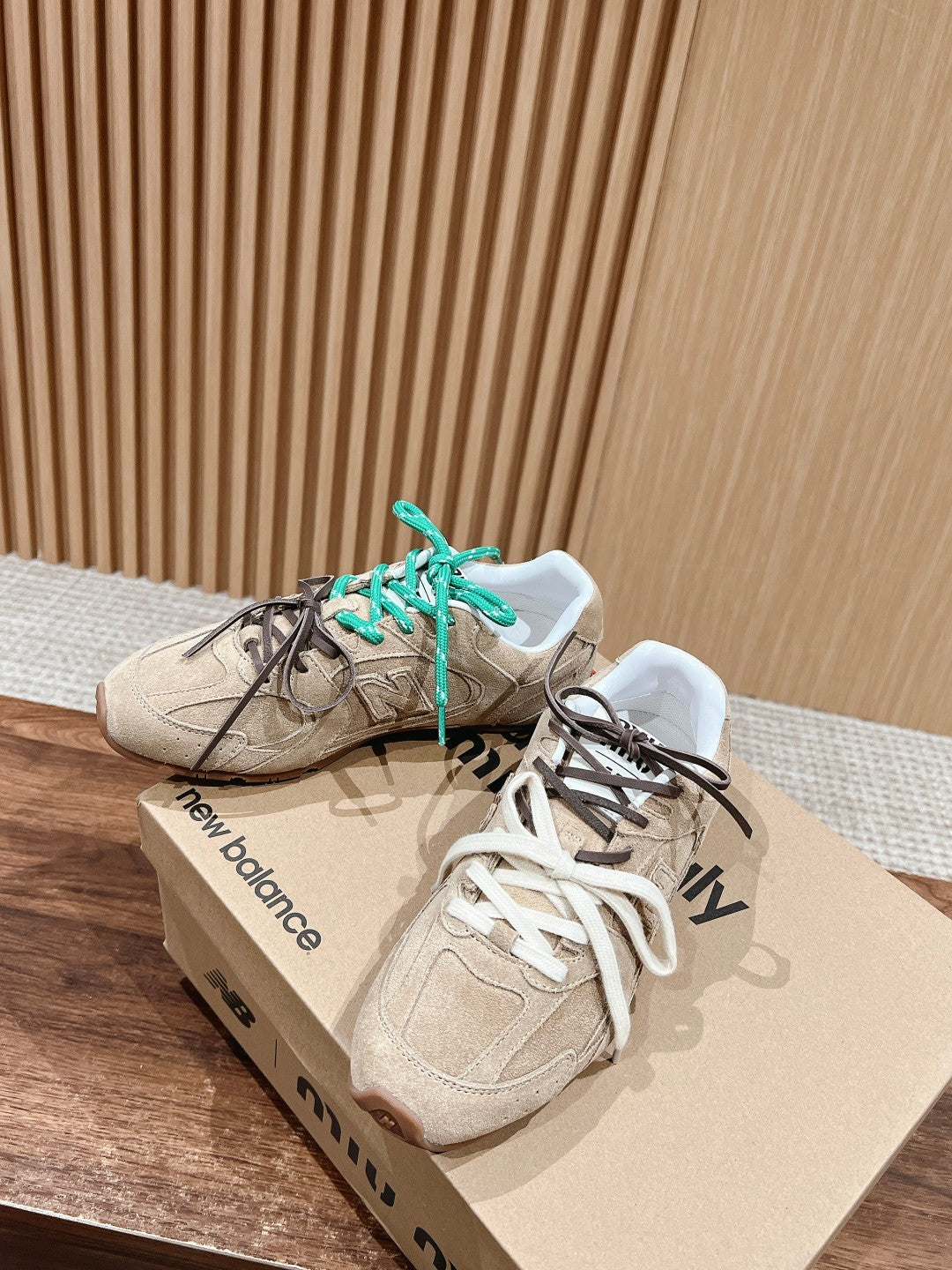 Unisex suede sneakers with green and black laces on brand box
