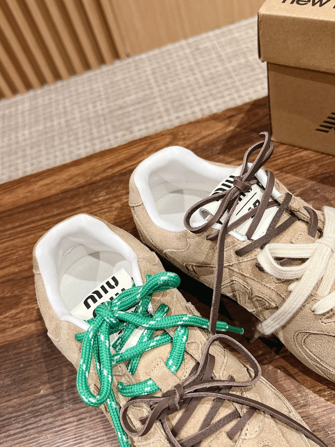 Unisex suede sneakers with green and brown laces, white inner lining visible