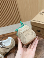 Unisex suede sneakers with green laces, New Balance logo detail, hand-held